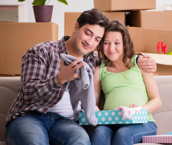 Молодая пара мужчин и беременная жена с подарочной коробкой — стоковое фото