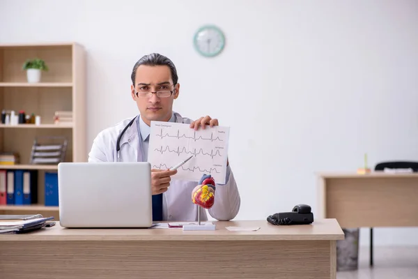 Giovane medico di sesso maschile cardiologo alla ricerca elettrocardiogramma — Foto Stock