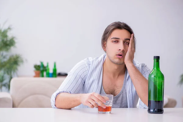 Fiatal férfi alkoholista whiskey-t iszik otthon — Stock Fotó