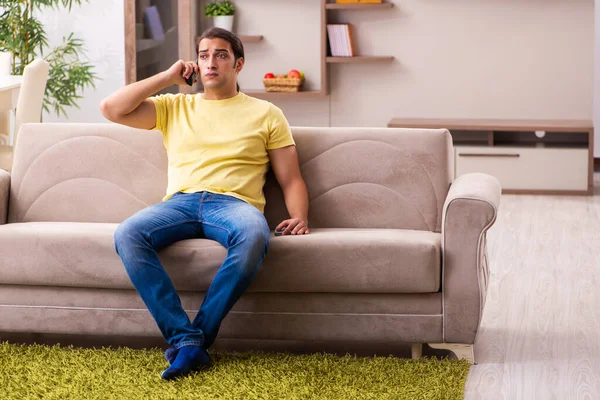 Jovem estudante falando por telefone em casa — Fotografia de Stock