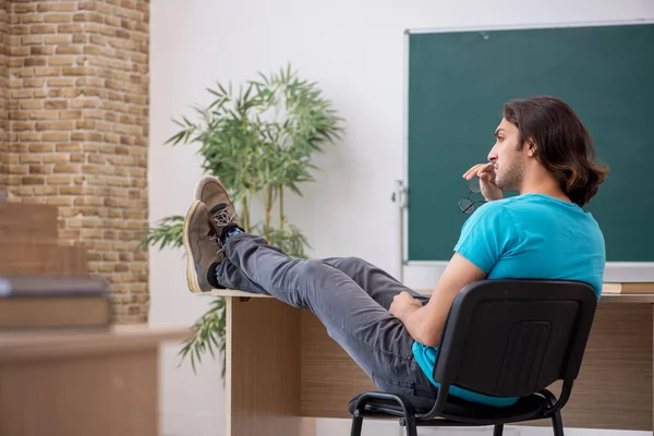 Jonge mannelijke student voor het groene bord — Stockfoto