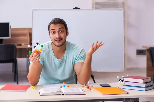 Ung manlig student fysiker studerar molekylär modell hemma — Stockfoto