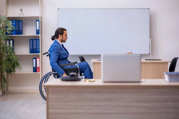 Junge männliche Angestellte im Rollstuhl bei der Arbeit im Büro — Stockfoto