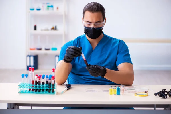 Giovani biochimici maschi testano campioni di sangue nel concetto di pandemia — Foto Stock