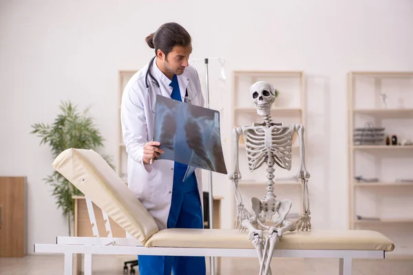 Jovem médico radiologista e paciente esqueleto na clínica — Fotografia de Stock