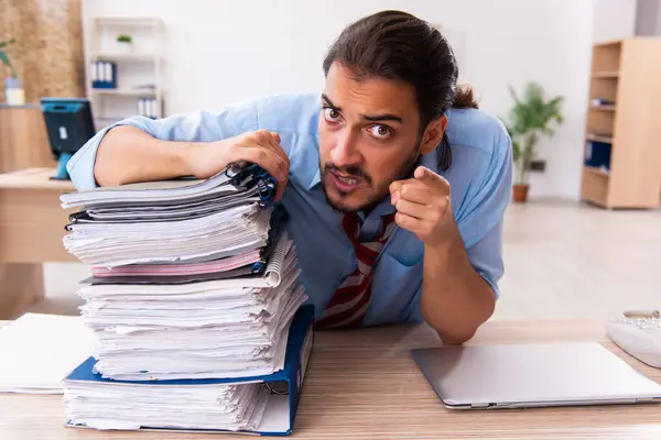 Jovem funcionário masculino infeliz com excesso de trabalho no escritório — Fotografia de Stock