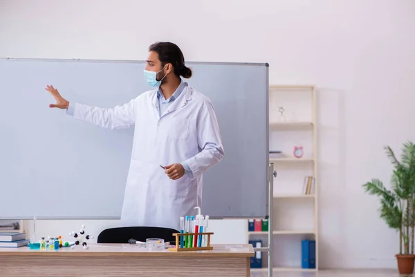 Joven profesor químico sentado en el aula — Foto de Stock