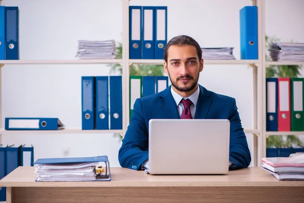 Joven empleado masculino y demasiados trabajan en la oficina — Foto de Stock