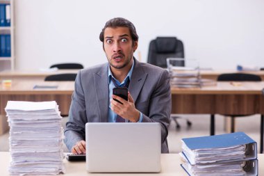 Ofisteki aşırı işten memnun olmayan genç bir erkek işçi.