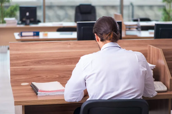 Jeune employé masculin et trop de travail au bureau — Photo