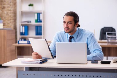 Ofiste çalışan genç bir erkek.