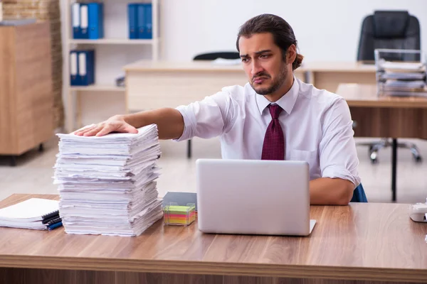 Joven empleado masculino descontento con el trabajo excesivo en la oficina — Foto de Stock