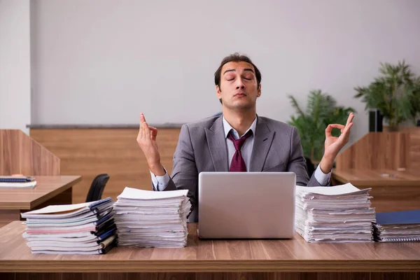 Joven empleado masculino descontento con el trabajo excesivo en la oficina — Foto de Stock