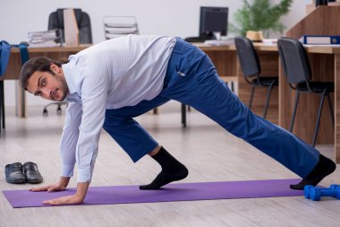 Mola sırasında spor yapan genç erkek çalışanlar.