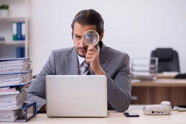 Jonge mannelijke werknemer ongelukkig met overmatig werk in het kantoor — Stockfoto