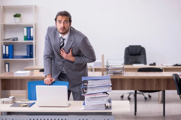 Junge männliche Angestellte unzufrieden mit exzessiver Arbeit im Büro — Stockfoto