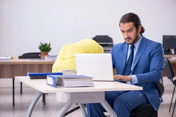 Jonge mannelijke werknemer die op de werkplek voor pasgeborenen zorgt — Stockfoto