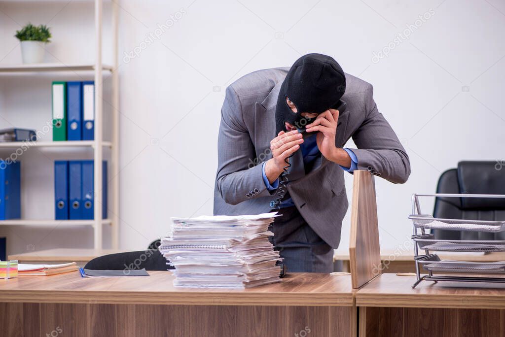 Young male employee in industrial espionage concept
