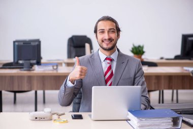 Ofiste çalışan genç bir erkek.