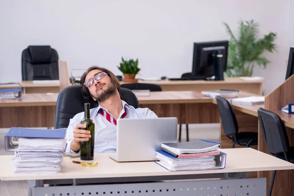 Giovane dipendente maschio che beve alcol in ufficio — Foto Stock