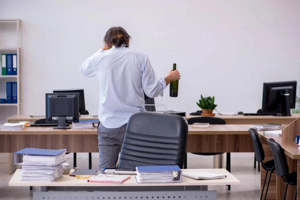 Jeune employé de sexe masculin buvant de l'alcool au bureau — Photo