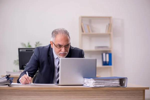 Betagter Geschäftsmann sitzt im Büro — Stockfoto