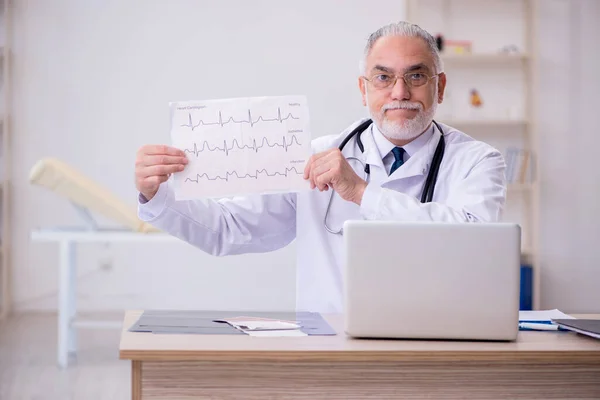 Klinikte çalışan yaşlı bir erkek kardiyolog. — Stok fotoğraf