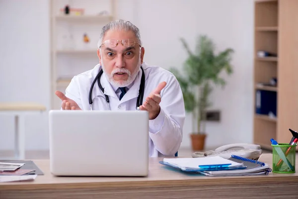 Teletıp konseptinde yaşlı bir doktor. — Stok fotoğraf