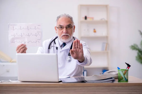 Old male doctor cardiologist working in the clinic — Stock Photo, Image