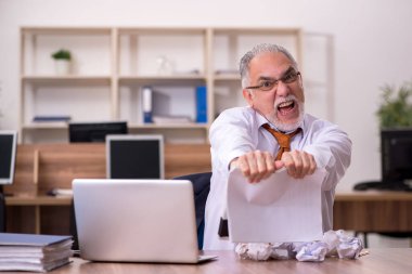 Kağıt geri dönüşümü konseptinde çalışan yaşlı bir erkek.