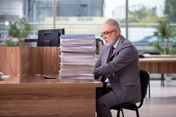 Старый бизнесмен и слишком много работы в офисе — стоковое фото