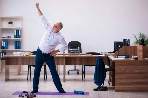 Vecchio impiegato uomo d'affari che fa esercizi sportivi in ufficio — Foto Stock