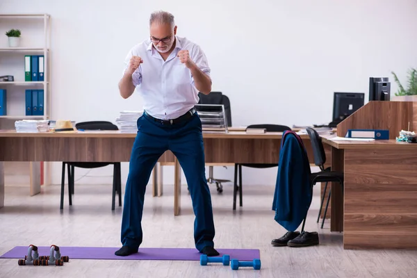 Vecchio impiegato uomo d'affari che fa esercizi sportivi in ufficio — Foto Stock