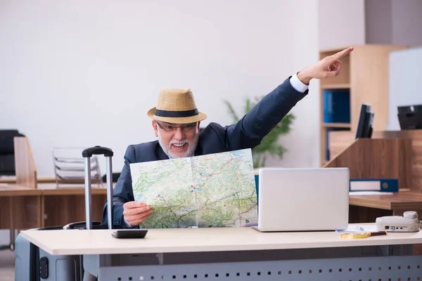 Egy idős férfi az irodában készül az utazásra — Stock Fotó