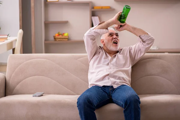 Ο γέρος πίνει αλκοόλ στο σπίτι. — Φωτογραφία Αρχείου