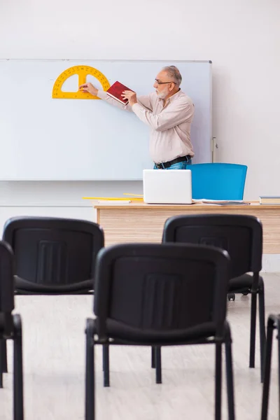 Vecchio insegnante di geometria maschile in classe nel concetto di pandemia — Foto Stock