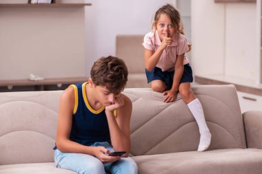 Oğlan ve küçük kız kardeşi salgın sırasında evde kalıyorlar.