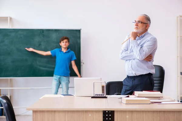 Yaşlı erkek öğretmen ve okul çocuğu sınıfta. — Stok fotoğraf