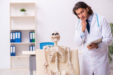 Deli doktor ölü hastayı muayene ediyor.