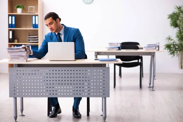 Jovem funcionário masculino infeliz com excesso de trabalho no escritório — Fotografia de Stock