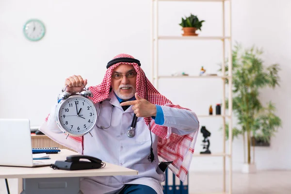 Viejo médico árabe masculino en concepto de gestión del tiempo — Foto de Stock