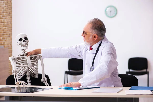 Γέρος άνδρας γιατρός και σκελετός ασθενής στην κλινική — Φωτογραφία Αρχείου