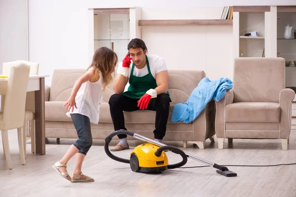 Jonge mannelijke aannemer schoonmaken van het huis met zijn kleine dochter — Stockfoto