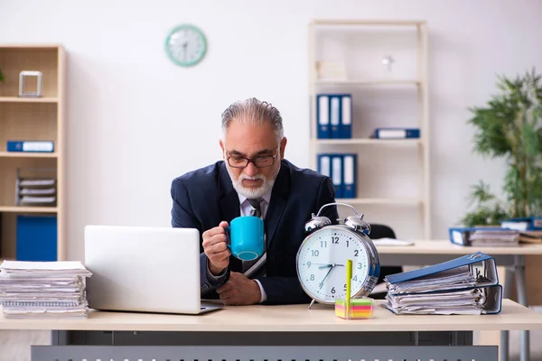 Старый бизнесмен пьет кофе в концепции управления временем — стоковое фото