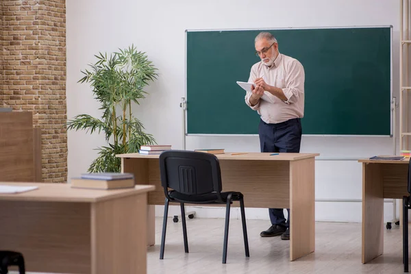 Tahtanın önünde yaşlı bir erkek öğretmen. — Stok fotoğraf