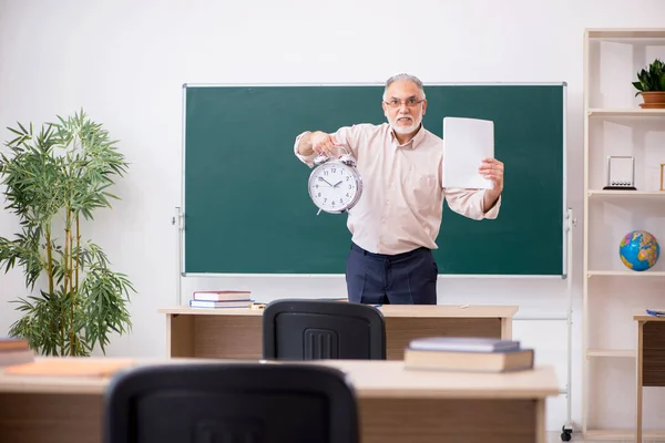 Oude mannelijke leraar in time management concept — Stockfoto