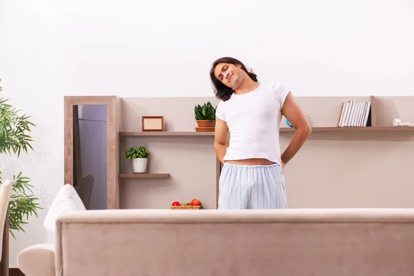 Jovem preguiçoso no conceito de dormir demais em casa — Fotografia de Stock