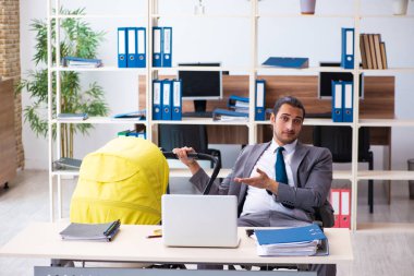 İş yerinde yeni doğan bebeğe bakan genç bir erkek işçi.