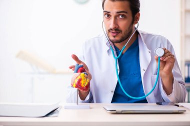 Klinikte çalışan genç bir erkek kardiyolog.