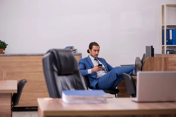 Junge männliche Mitarbeiter sitzen am Arbeitsplatz — Stockfoto
